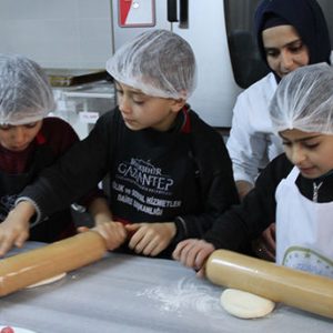 أطفال سوريون يلبسون قبعات الطهاة الكبار