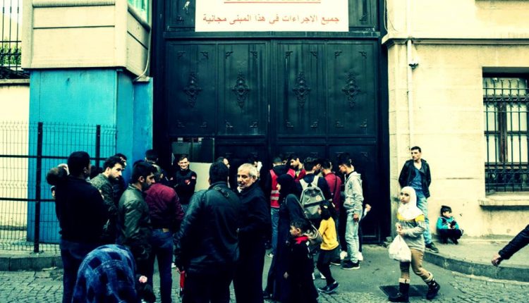 سوريون أمام بوابة لدائرة الهجرة في إسطنبول